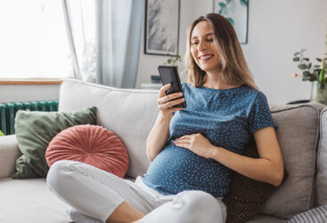 Kobieta w ciąży trzymająca się za brzuch