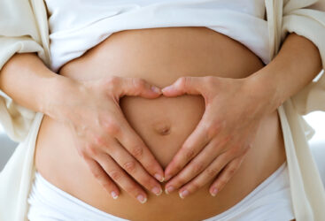 Kobieta w ciąży trzymająca się za brzuch